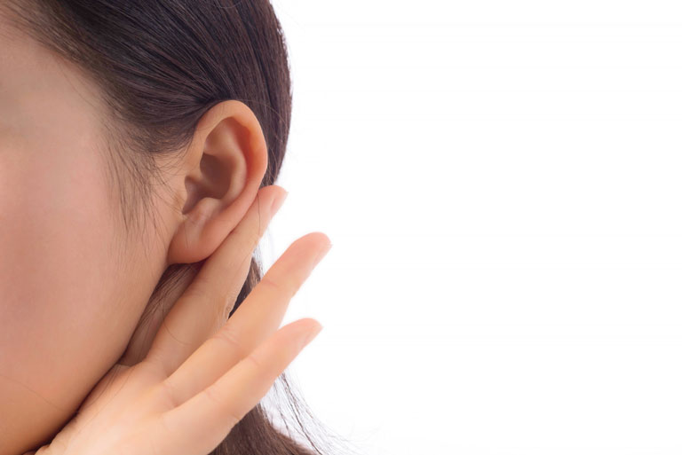 Costado de rostro femenino con mano detras de la oreja