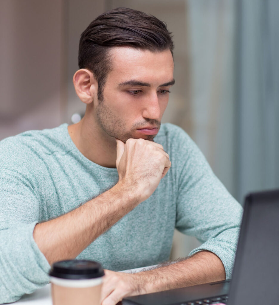 hombre joven mirando información en un laptop negro