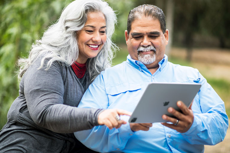 pareja de adultos canosos mirando una tablet