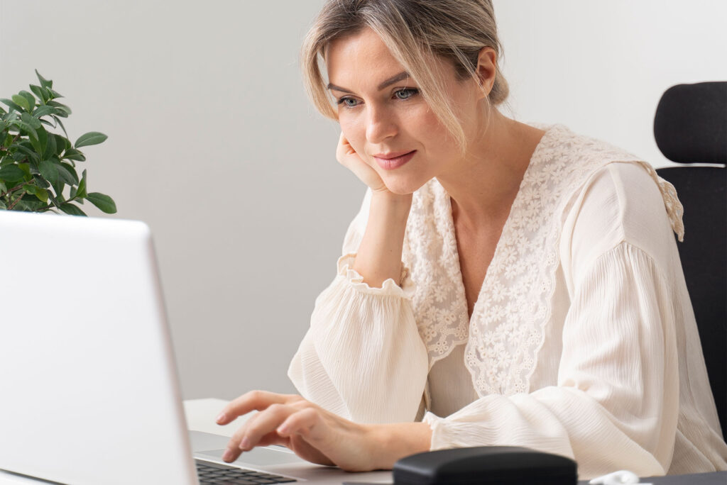 Mujer adulta haciendo clic en su laptop gris